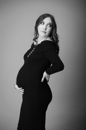 Dramatic black and white maternity photo series showing silhouette poses against gradient background.