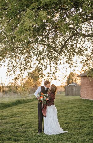 Romantic sunset photoshoot in a grassy field with overhanging tree branches.