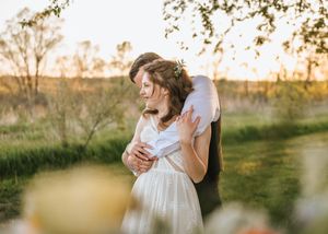 Golden hour couple photography session under tree branches in rural setting.