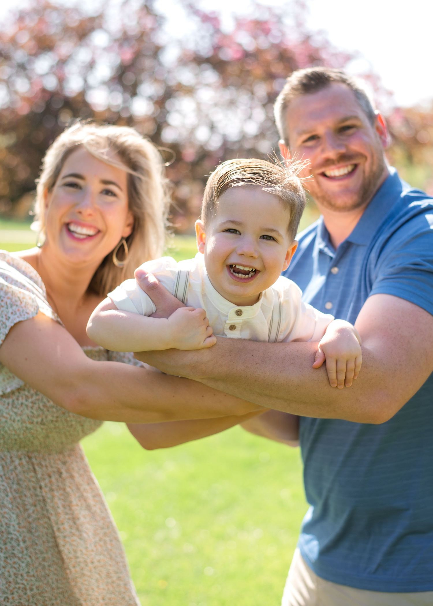 A happy family enjoying a sunny day outdoors together with blurred autumn trees in the background.