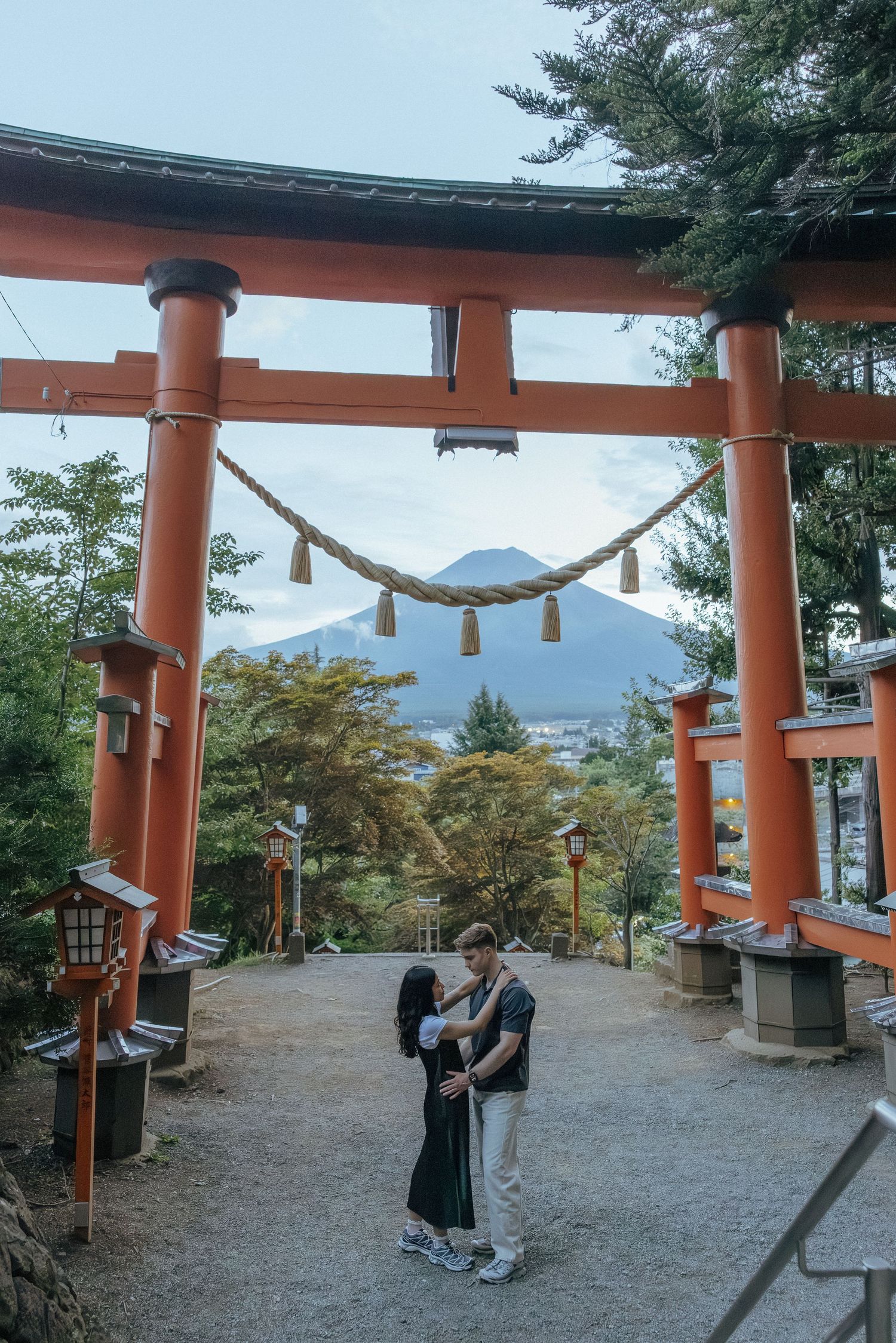 Engagement photoshoot around traditional orange torii gate of Chureito Pagoda with Mount Fuji visible in the background.