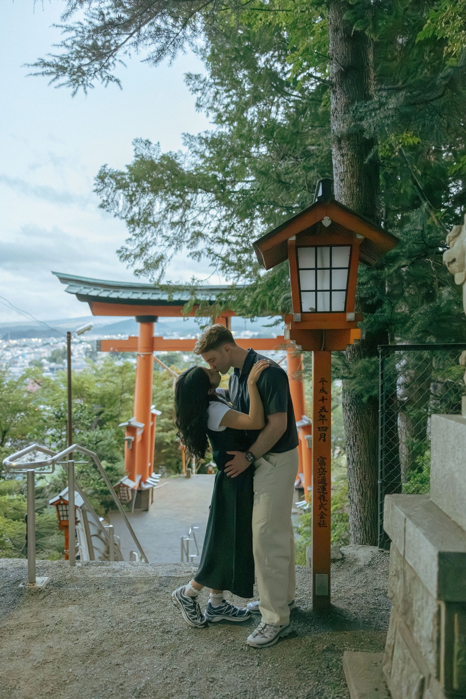 Engagement photoshoot around traditional orange torii gate of Chureito Pagoda with Mount Fuji visible in the background.