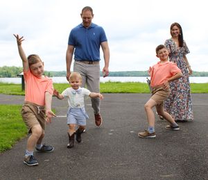 A sequence of photos shows a parent and child practicing jumping exercises together on a paved path outdoors.
