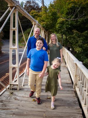 A sequence of playful moments on a wooden bridge walkway surrounded by autumn trees.