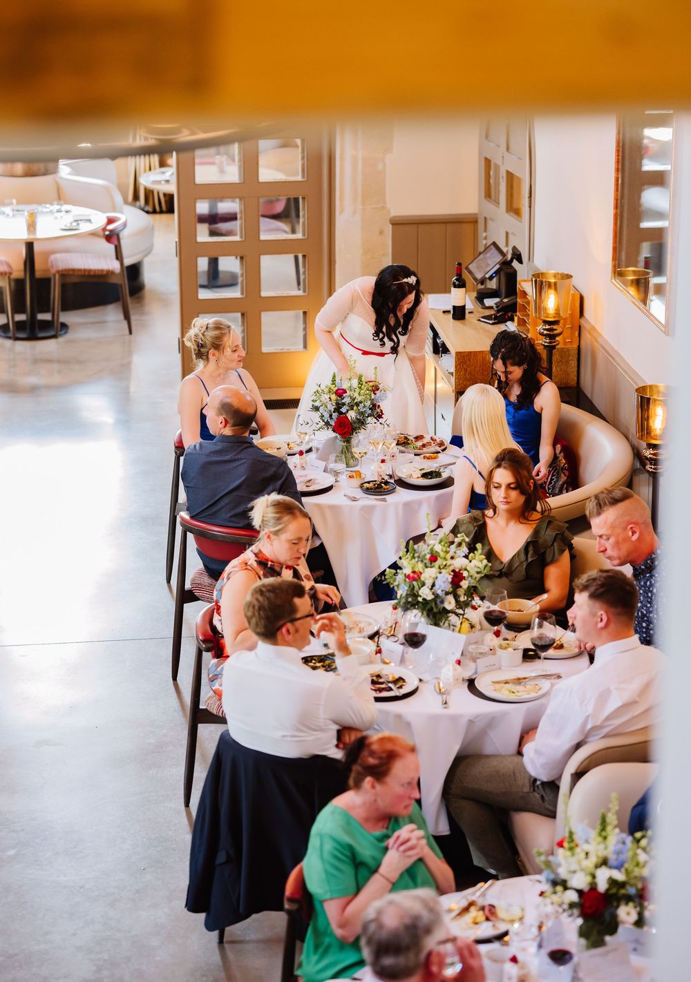 Wedding guests enjoy an intimate dinner reception at elegantly set round tables with floral centerpieces Relaxed Dorset Wedding photographer
