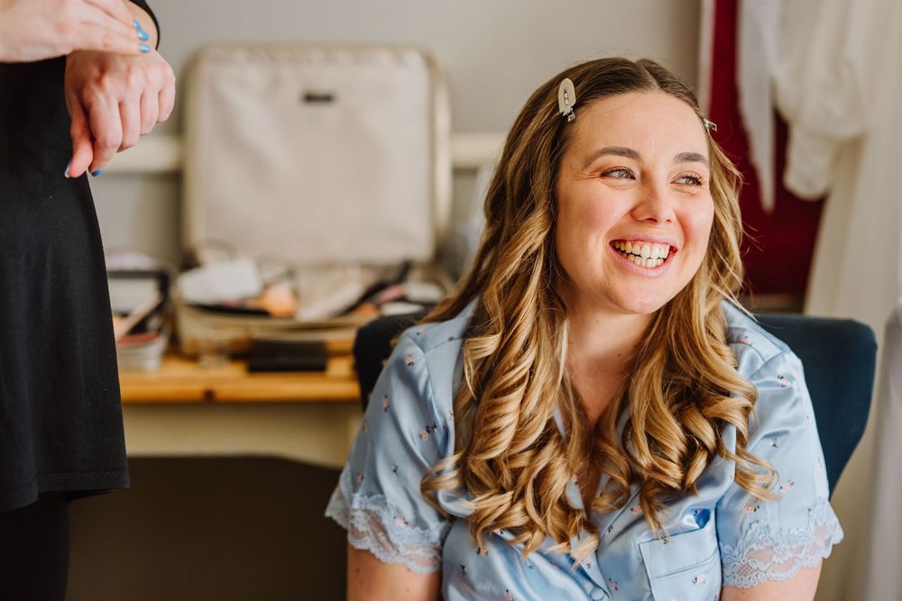 Bride candidly smiles whilst getting ready at the Alverbank Hotel Gosport. From a candid Hampshire Wedding Photographer