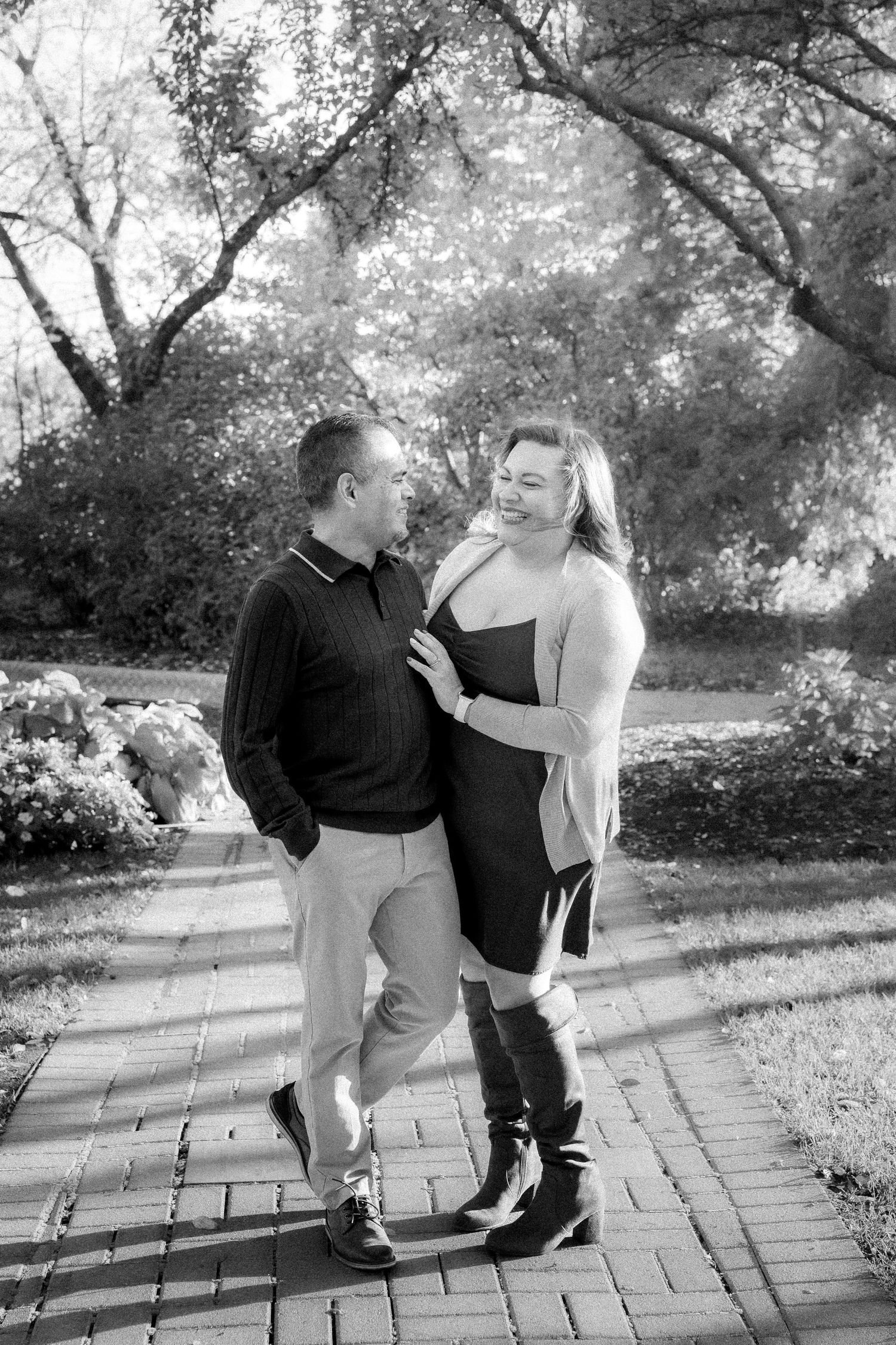 Black and white series of a couple sitting and posing on stone steps outdoors.