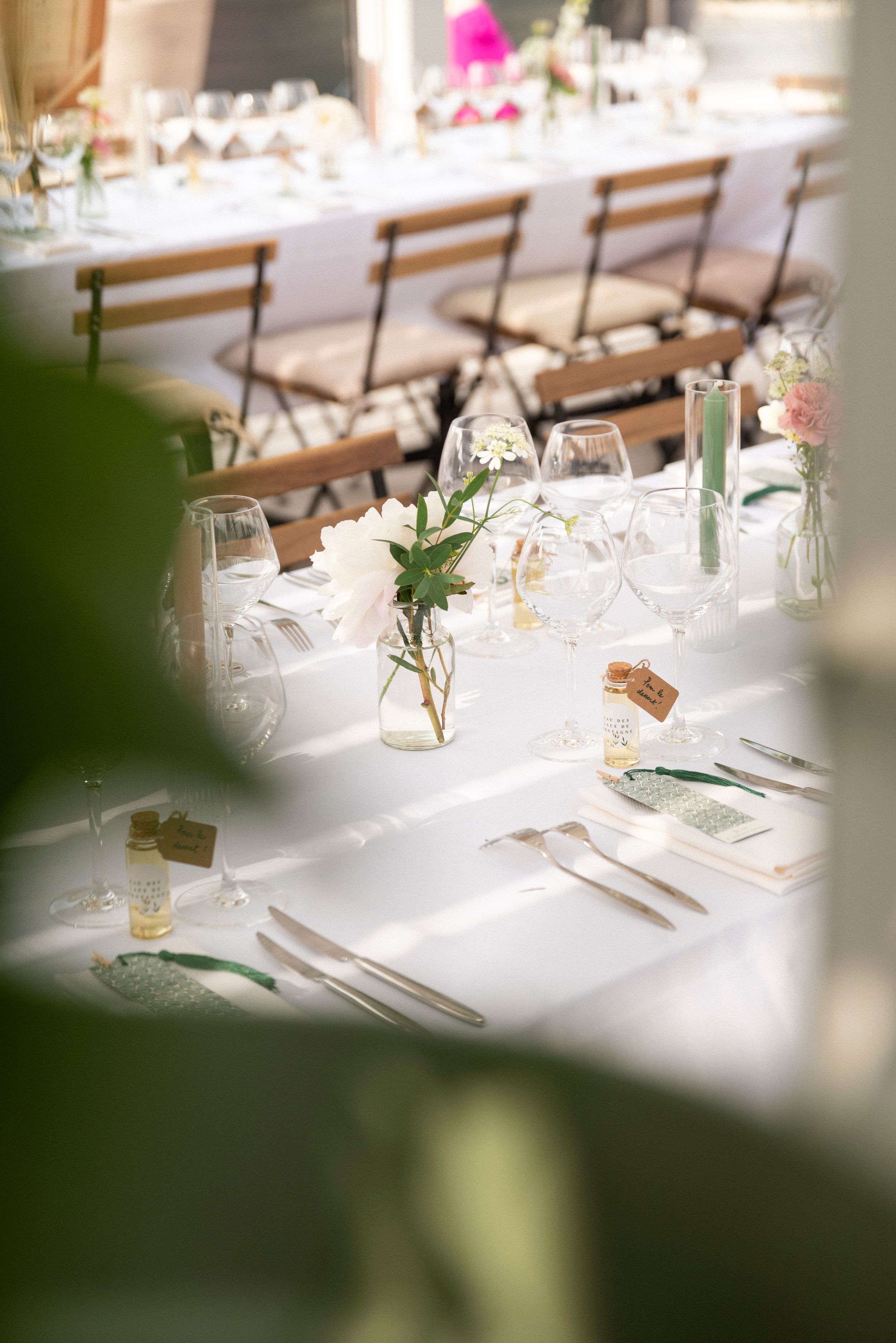 White tablecloth dining tables set with wine glasses and place settings in an elegant reception venue.