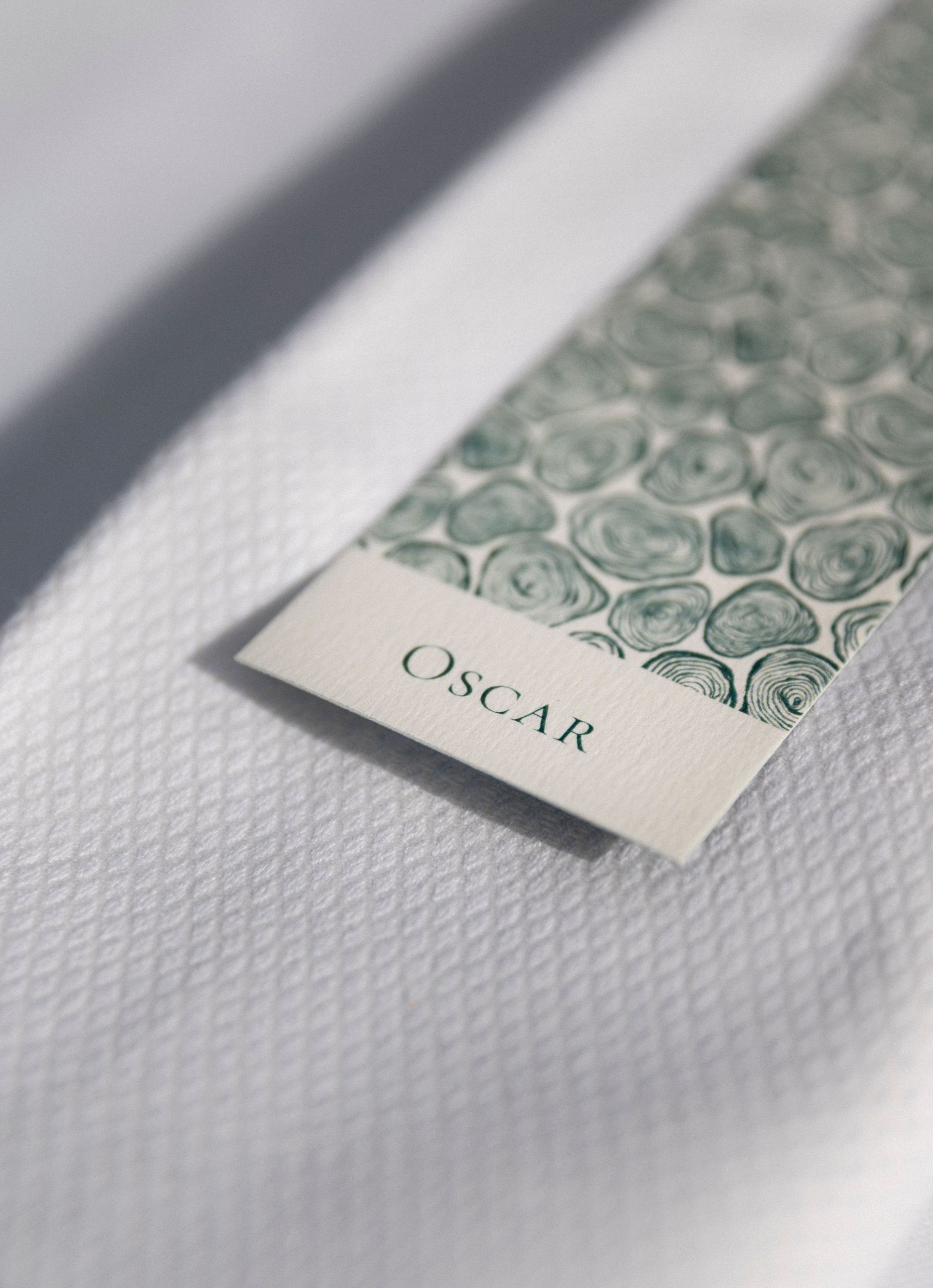 Close-up of elegant wedding invitation with embossed pattern and text on textured white paper.