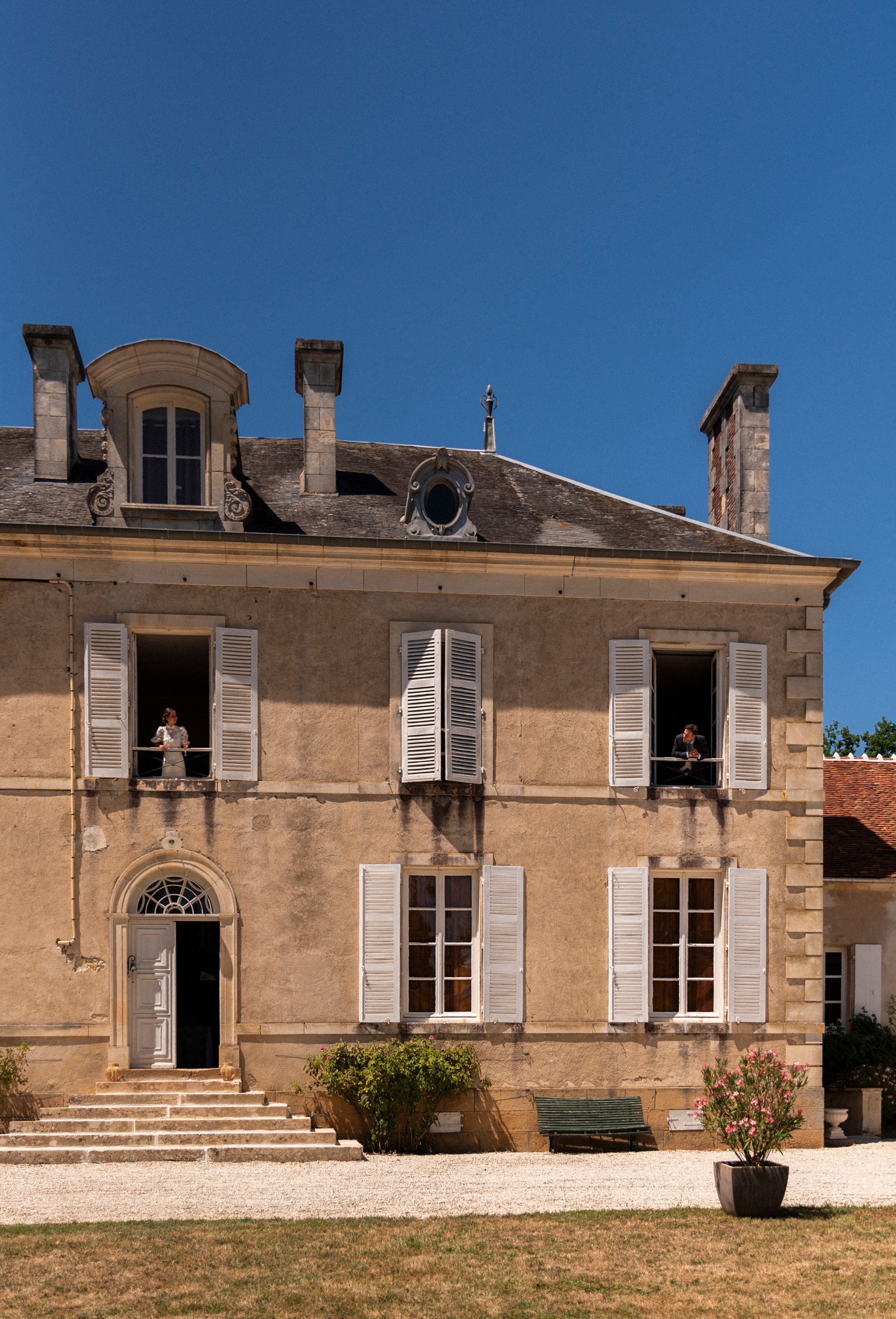 Historic French chateau exterior with multiple arched windows and stone facade shown from different angles in bright sunlight.