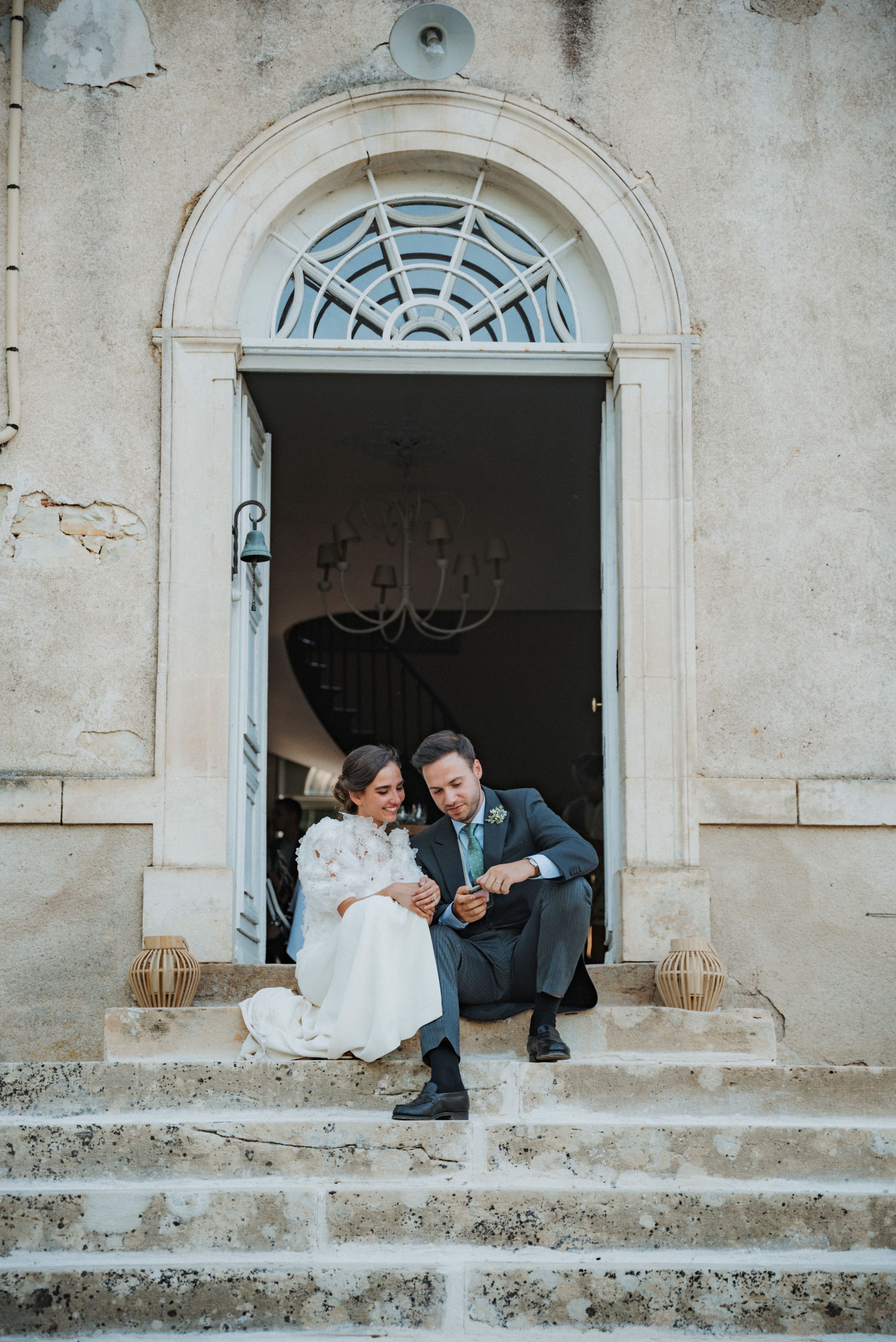 Creative wedding photo sequence showing couple peeking through arched stone windows of historic building.