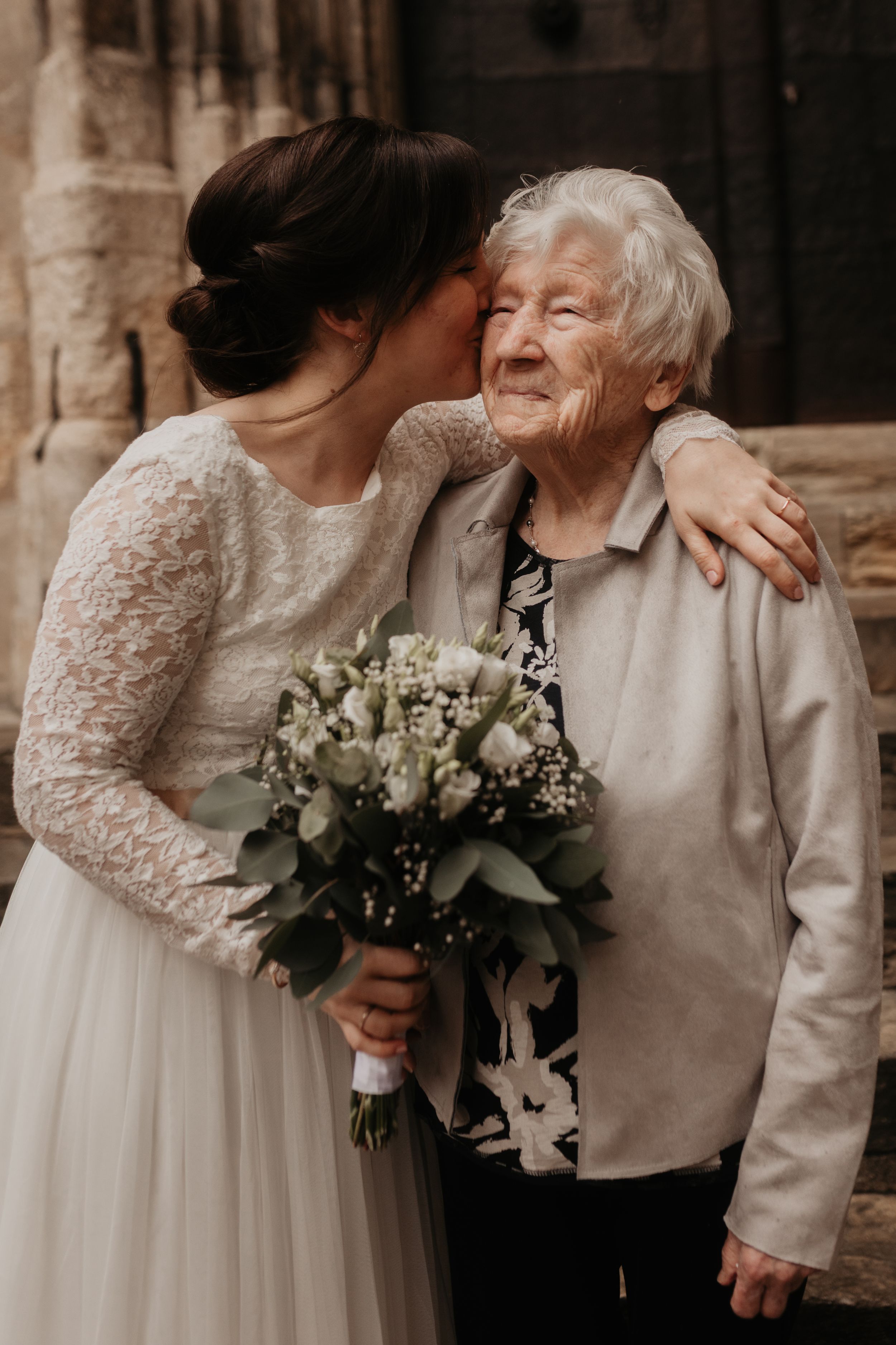 A tender moment captured in a series of wedding photos showing embraces and white floral bouquets.