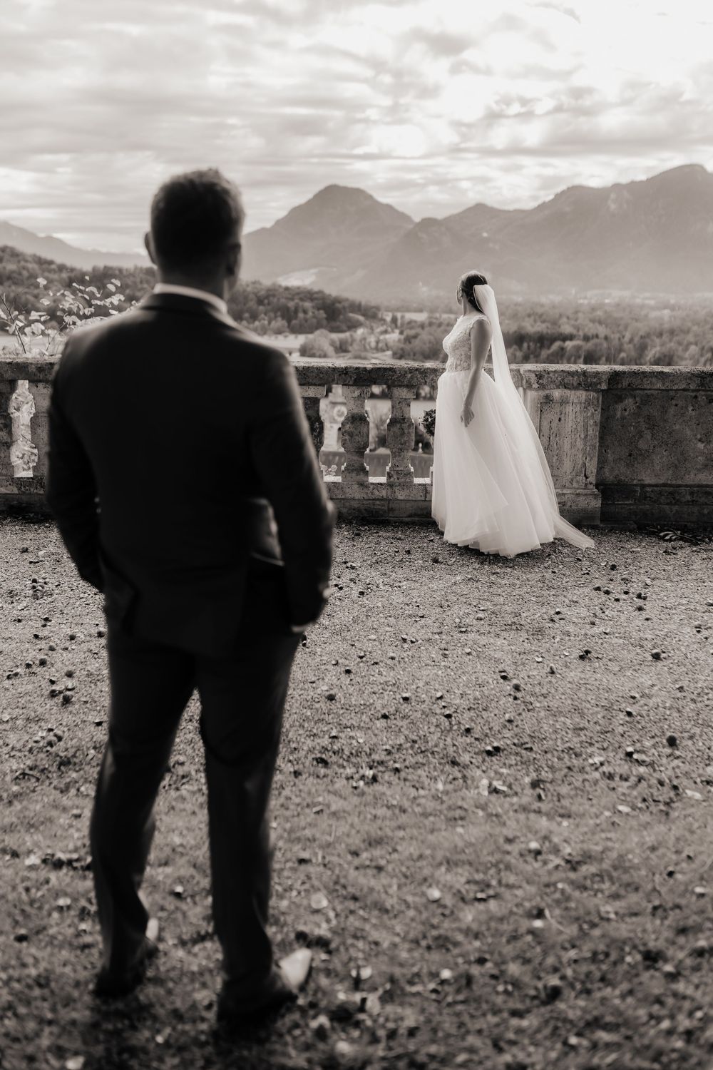 Black and white wedding photo series showing a couple on a scenic mountain overlook with dramatic cloudy skies.