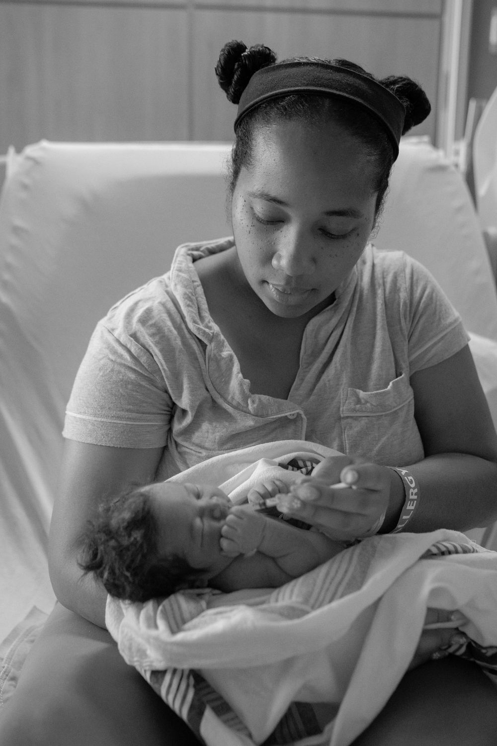 Black and white photo series showing tender moments between a caregiver and newborn baby in a hospital setting.