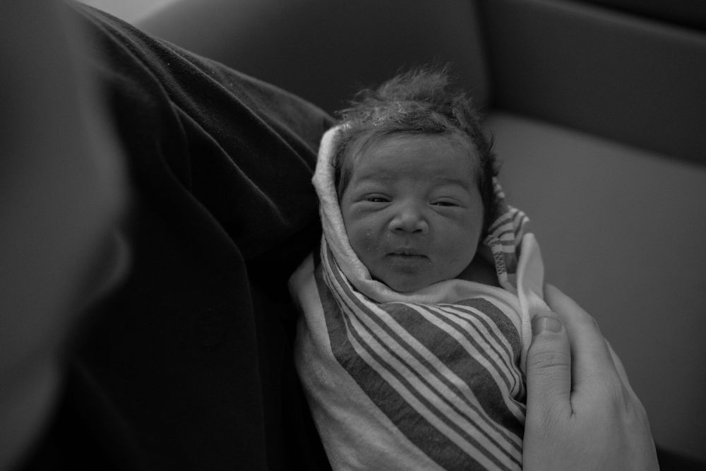 Black and white images showing a sleeping newborn baby in hospital.
