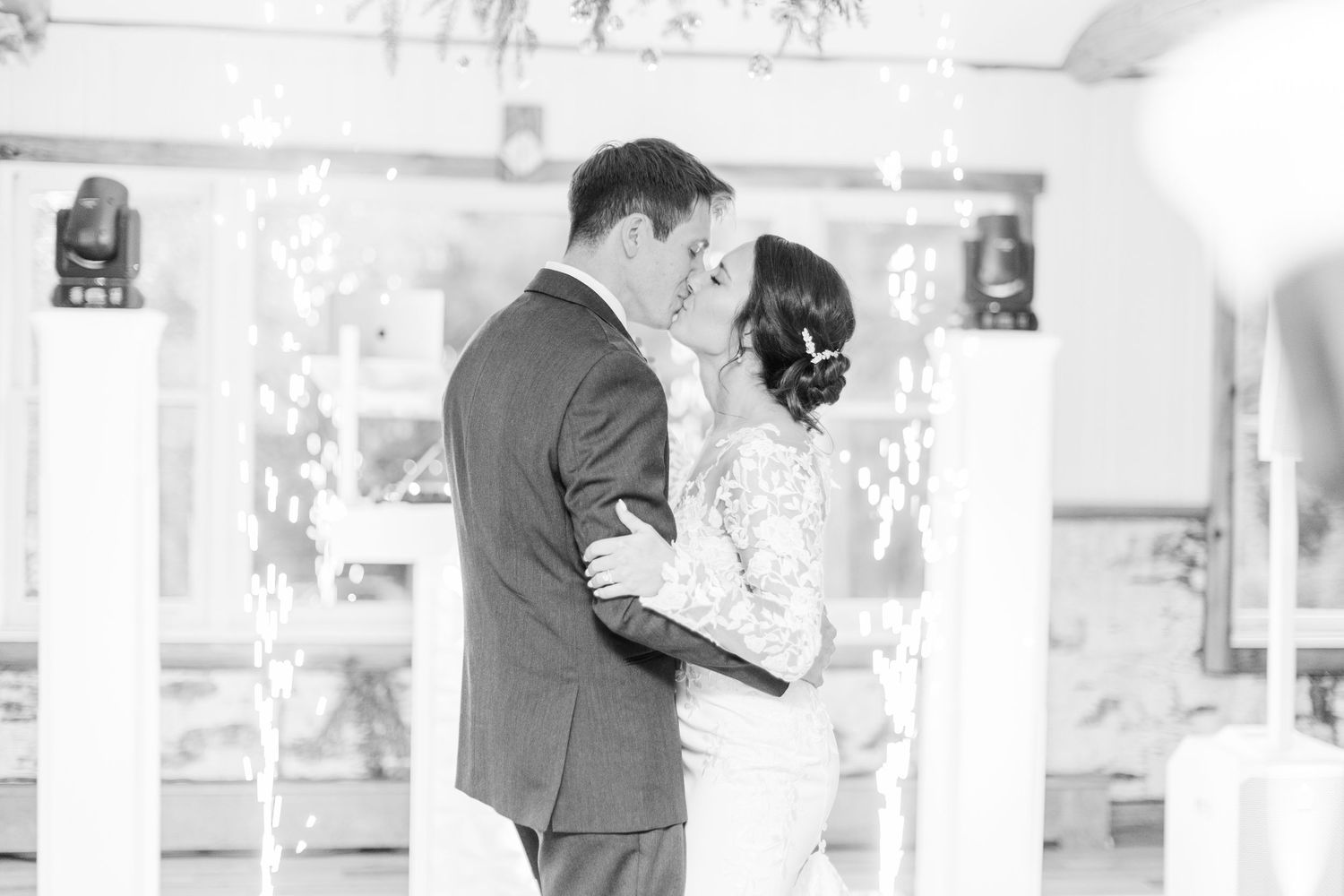 A couple shares their first dance together at their wedding reception in black and white photography.