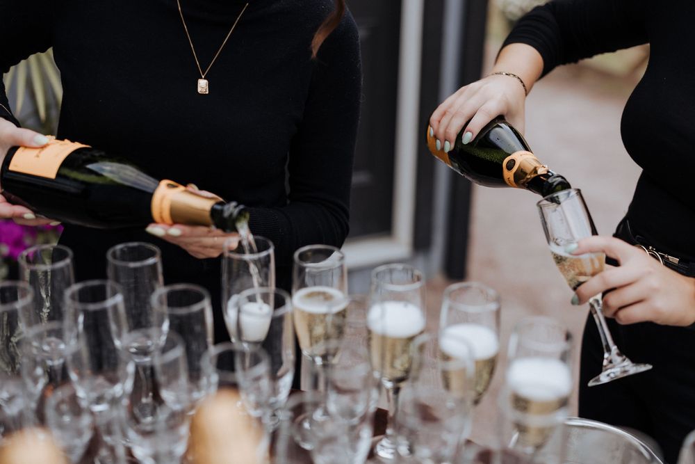 Staff pour guests champagne welcome drink upon arrive at intimate engagement party that turns into a surprise wedding Moncton New Brunswick