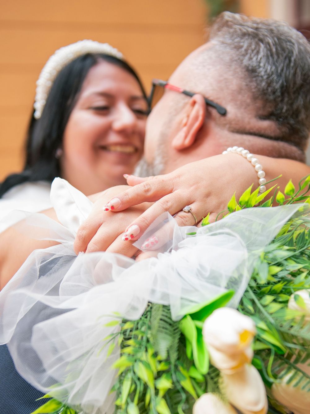 A romantic wedding moment captured in a sequence showing a couple sharing a tender kiss with white veil and greenery details.