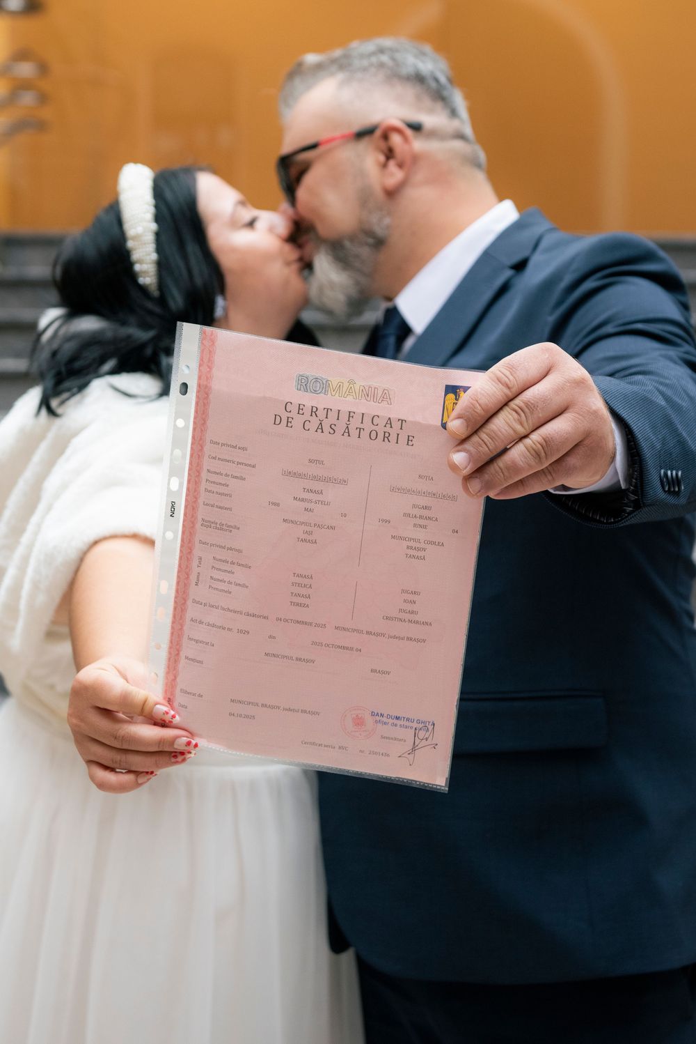 Marriage certificate being held and displayed during wedding ceremony documentation.