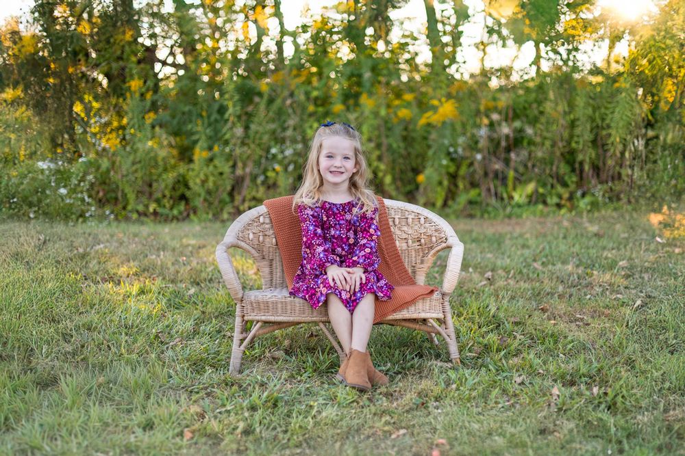 Springfield, IL Photographer captures a girl smiling on a bench during a photo session at Centennial Park in Springfield, IL