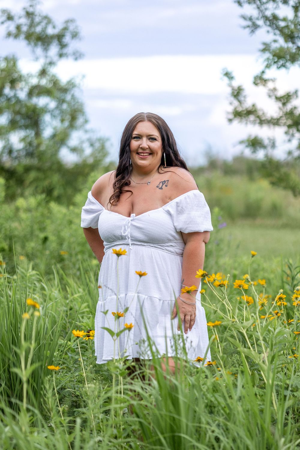 Springfield, IL Photographer captures a young lady smiles amongst wildflowers during a photo session at Centennial Park in Springfield, IL
