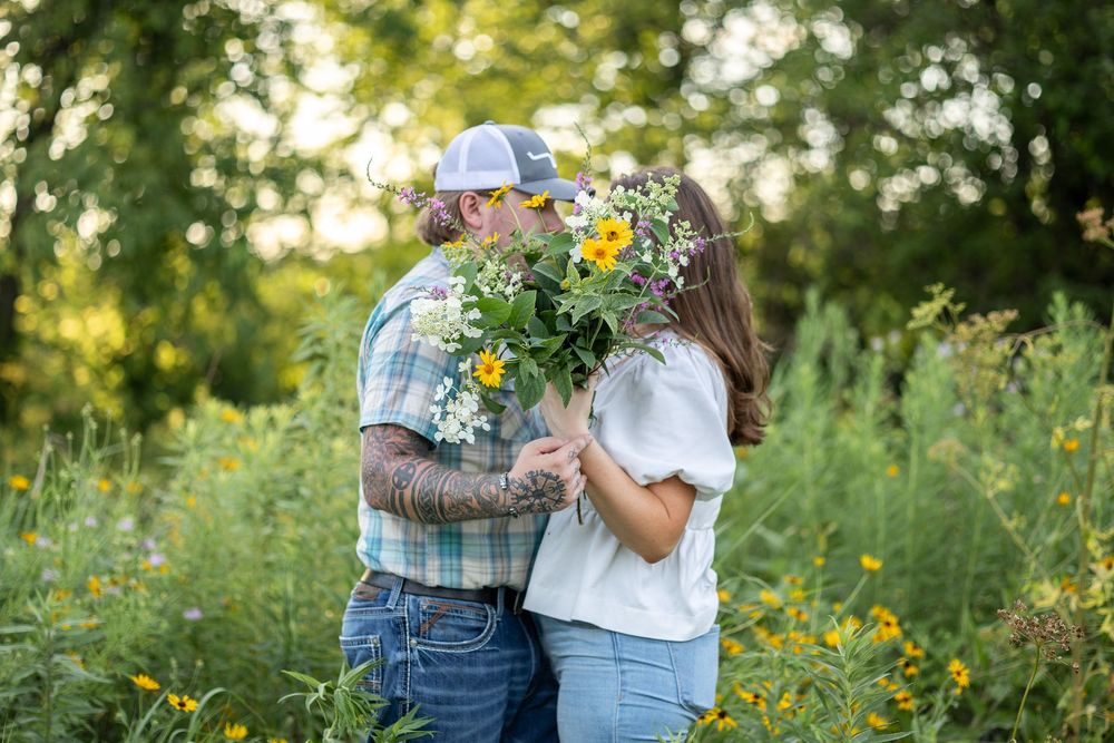 Springfield, IL Photographer captures a couple kiss behind a bouquet of flowers during a photo session at Centennial Park in Springfield, IL