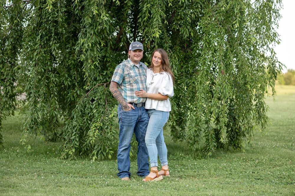 Springfield, IL Photographer captures a couple smiling by a tree during a photo session at Centennial Park in Springfield, IL