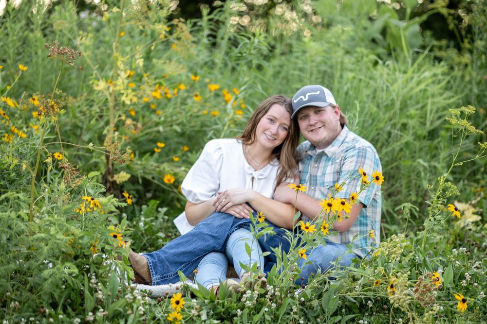 Springfield, IL Photographer captures a couple sitting in a wildflower field during a photo session at Centennial Park in Springfield, IL