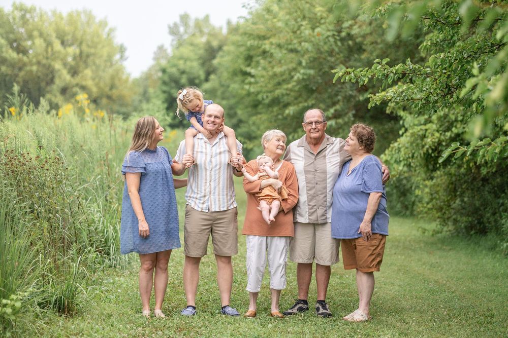 Springfield, IL Photographer captures a family gathers smiling at each other during a photo session at Centennial Park in Springfield, IL