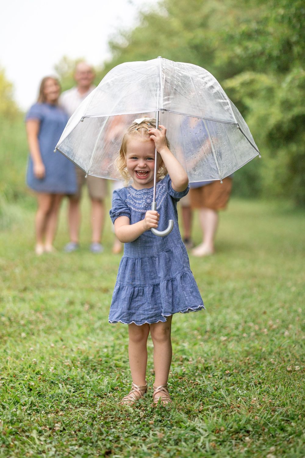 Springfield, IL Photographer captures a girl smiles and holds an umbrella during a photo session at Centennial Park in Springfield, IL