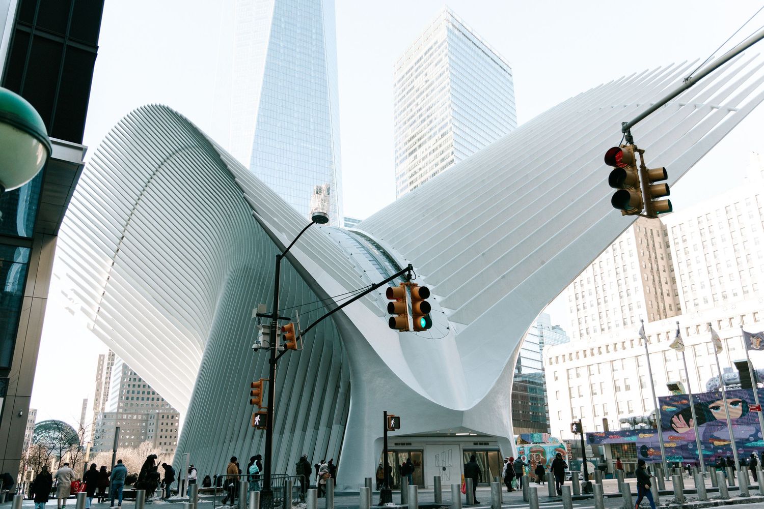 Modern white architectural structure with curved ribbed design against urban skyline.