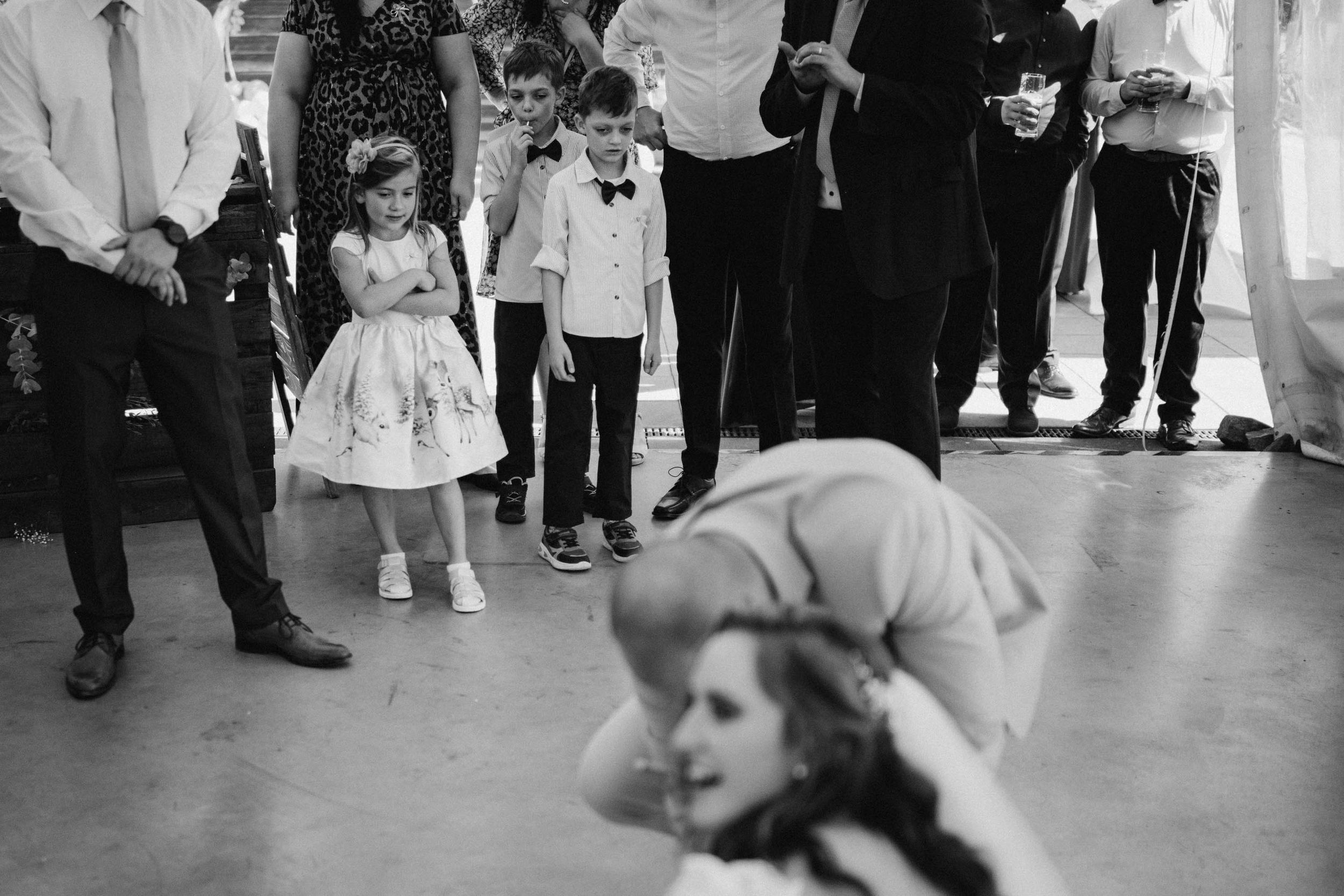 Wedding guests dancing and celebrating at an indoor reception venue.