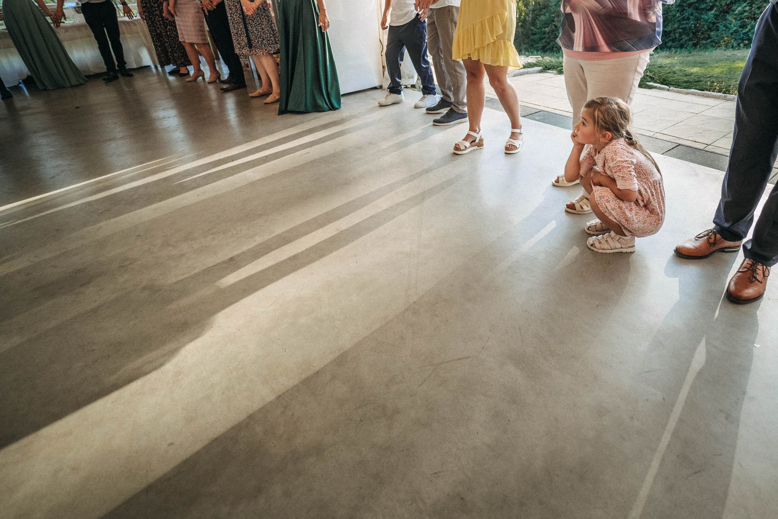 Low angle view of wedding guests dancing on a polished concrete floor.