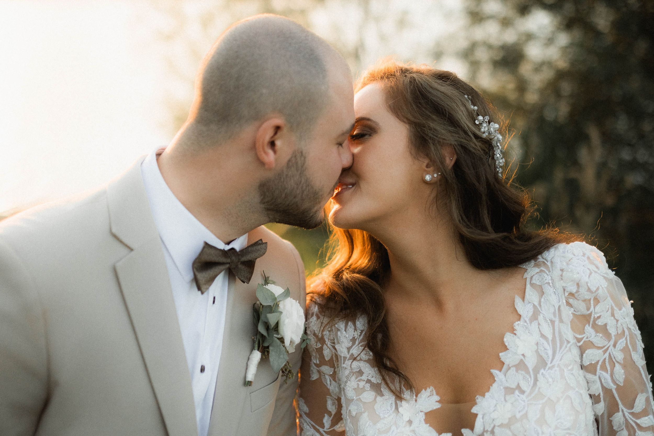 Romantic golden hour wedding portrait with couple sharing intimate moment.
