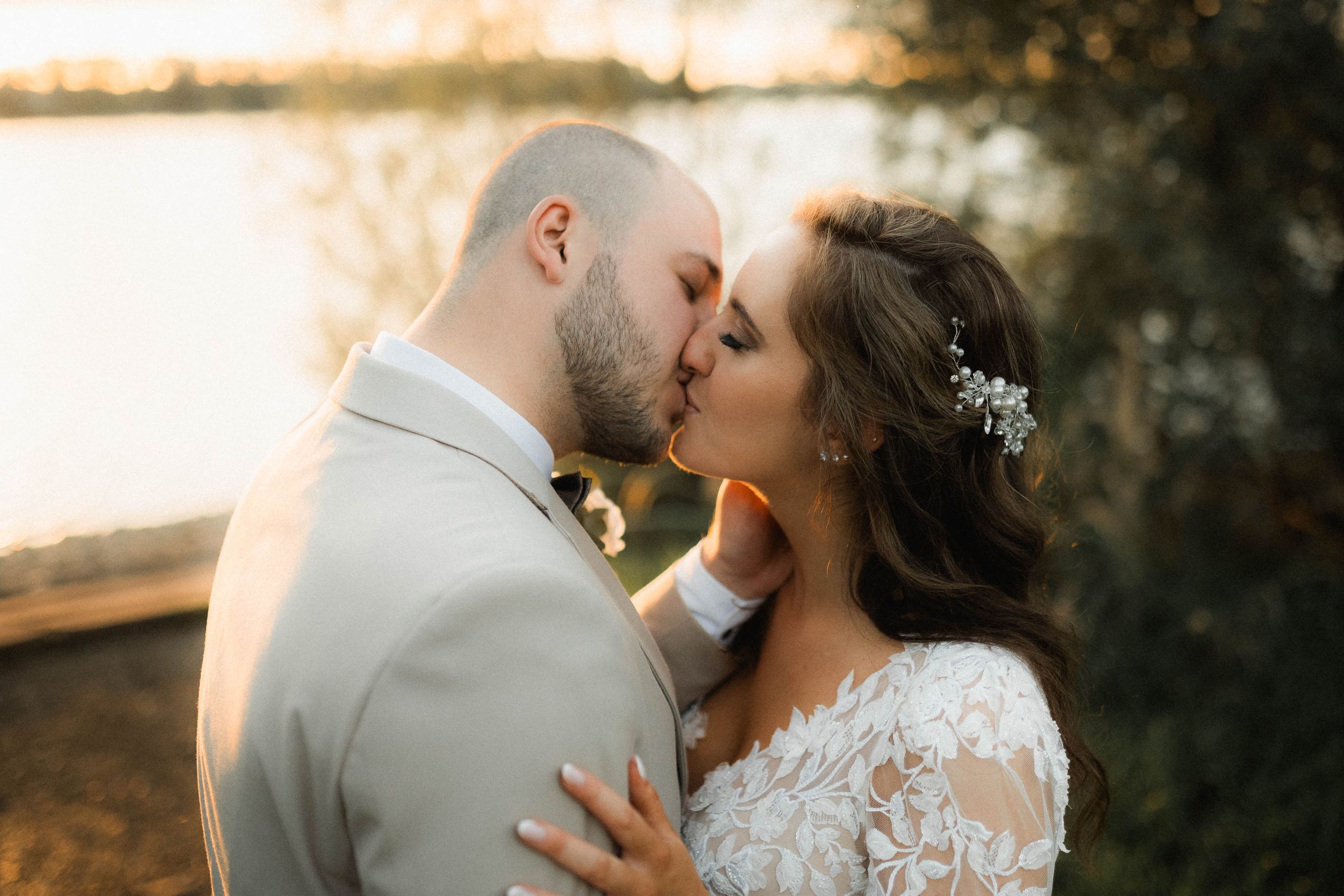 Intimate wedding portrait with couple sharing romantic moment at sunset.