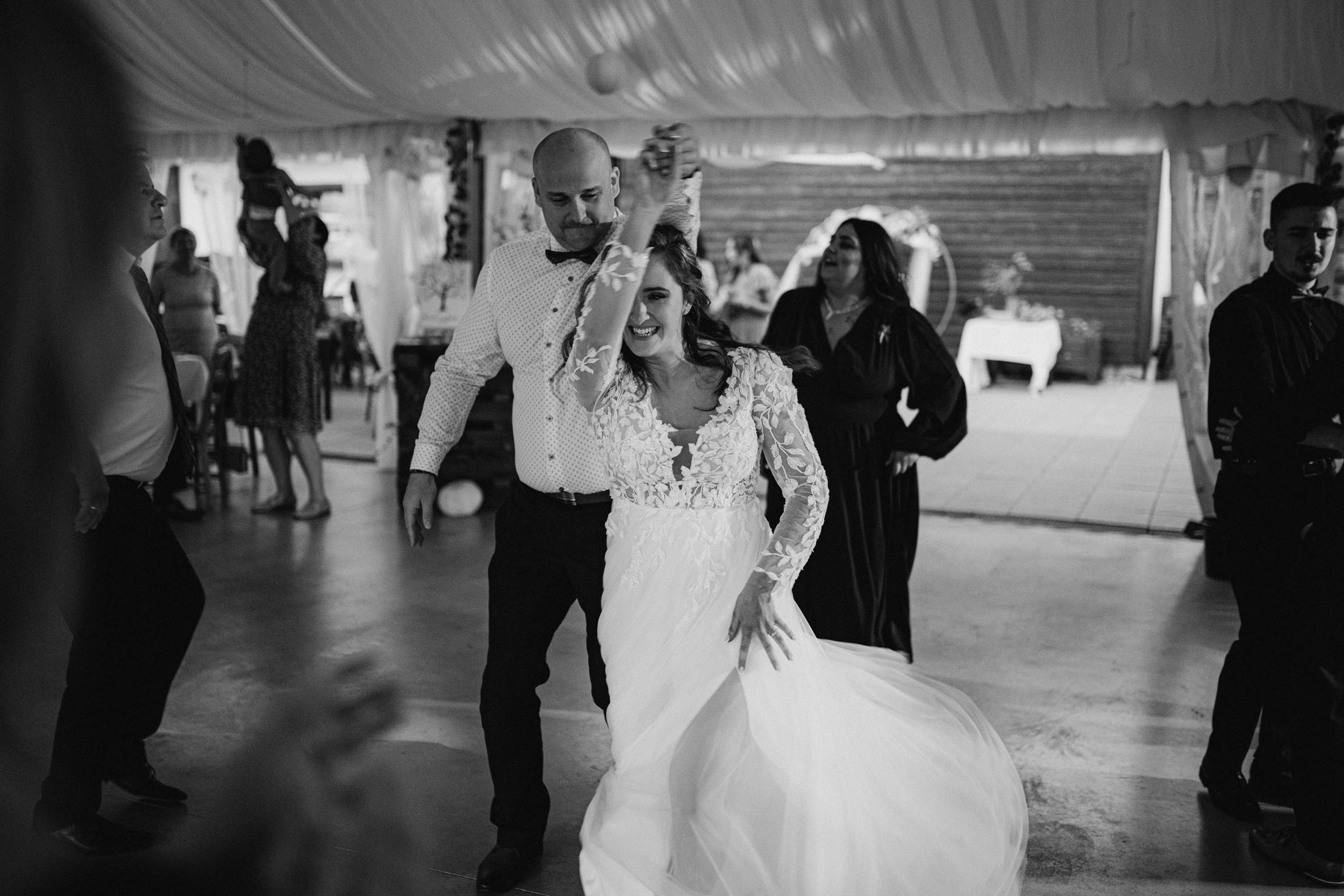 Black and white reception photos showing guests dancing and celebrating at an indoor venue.