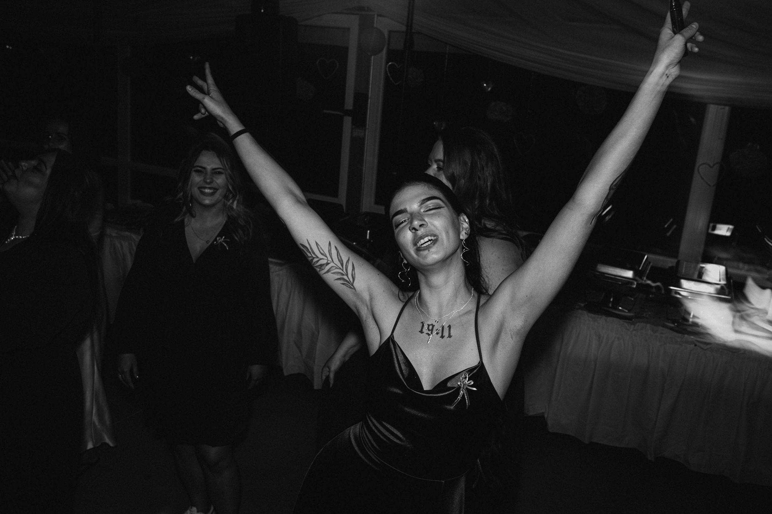 Energetic dance floor moments captured in black and white at a wedding reception.