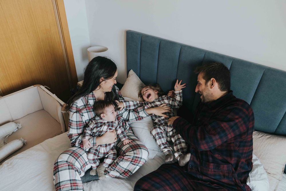 People relaxing on a couch while reading and browsing through magazines together.