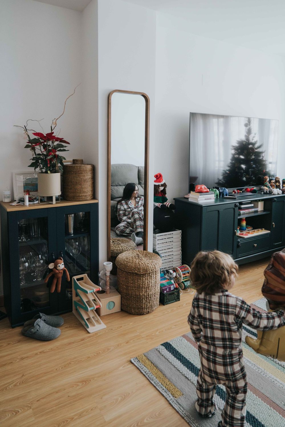 Series of photos showing a cozy living room with dark furniture, wooden floors, and holiday decorations arranged along a media unit.