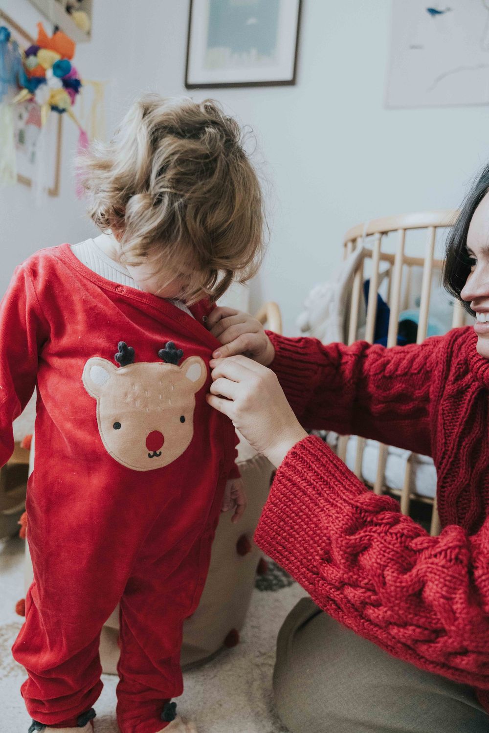 A series of photos showing a red sweater with cute embroidered details being adjusted and styled.
