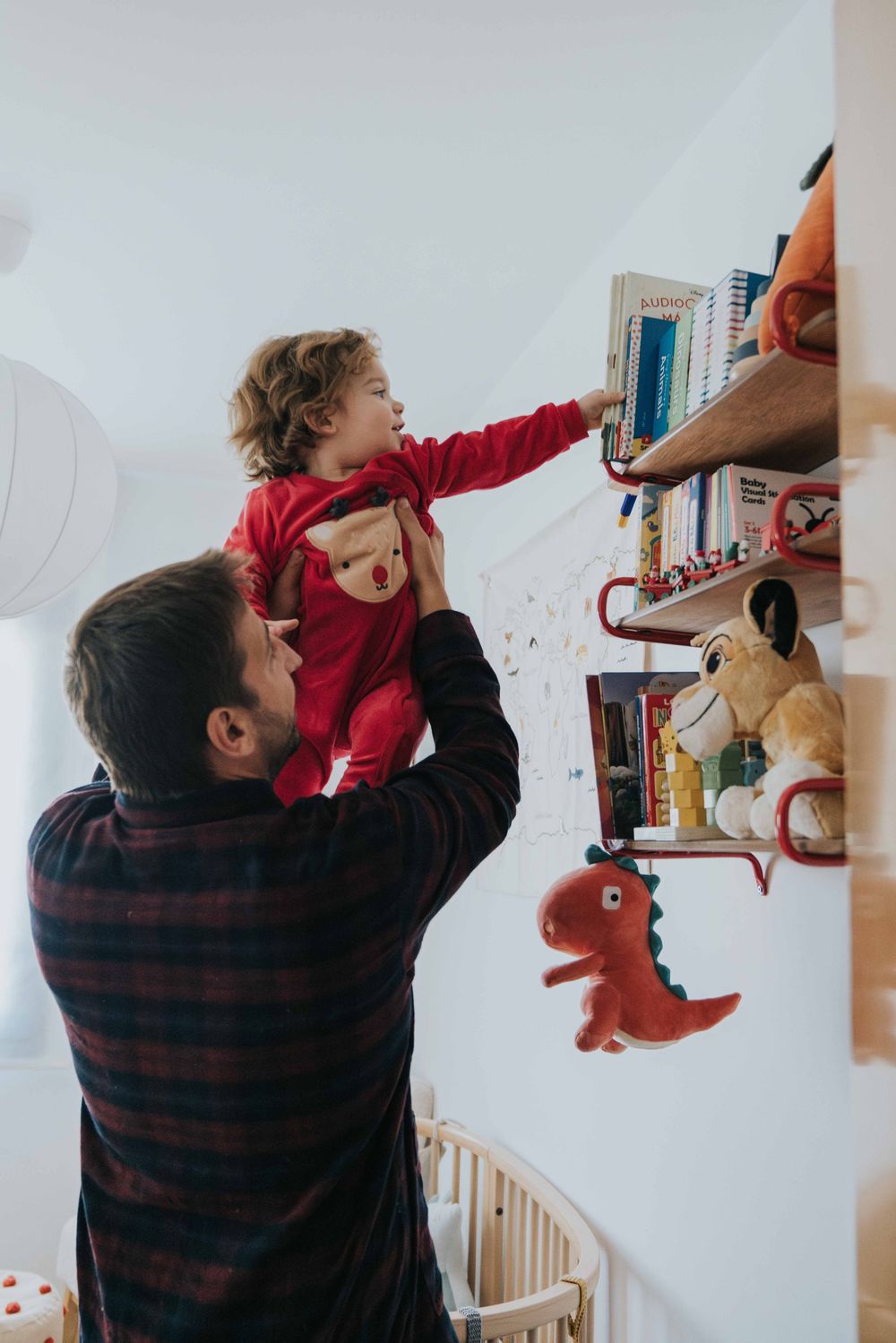 Sequence showing someone reaching up to arrange items on floating wall shelves decorated with stuffed toys and books.