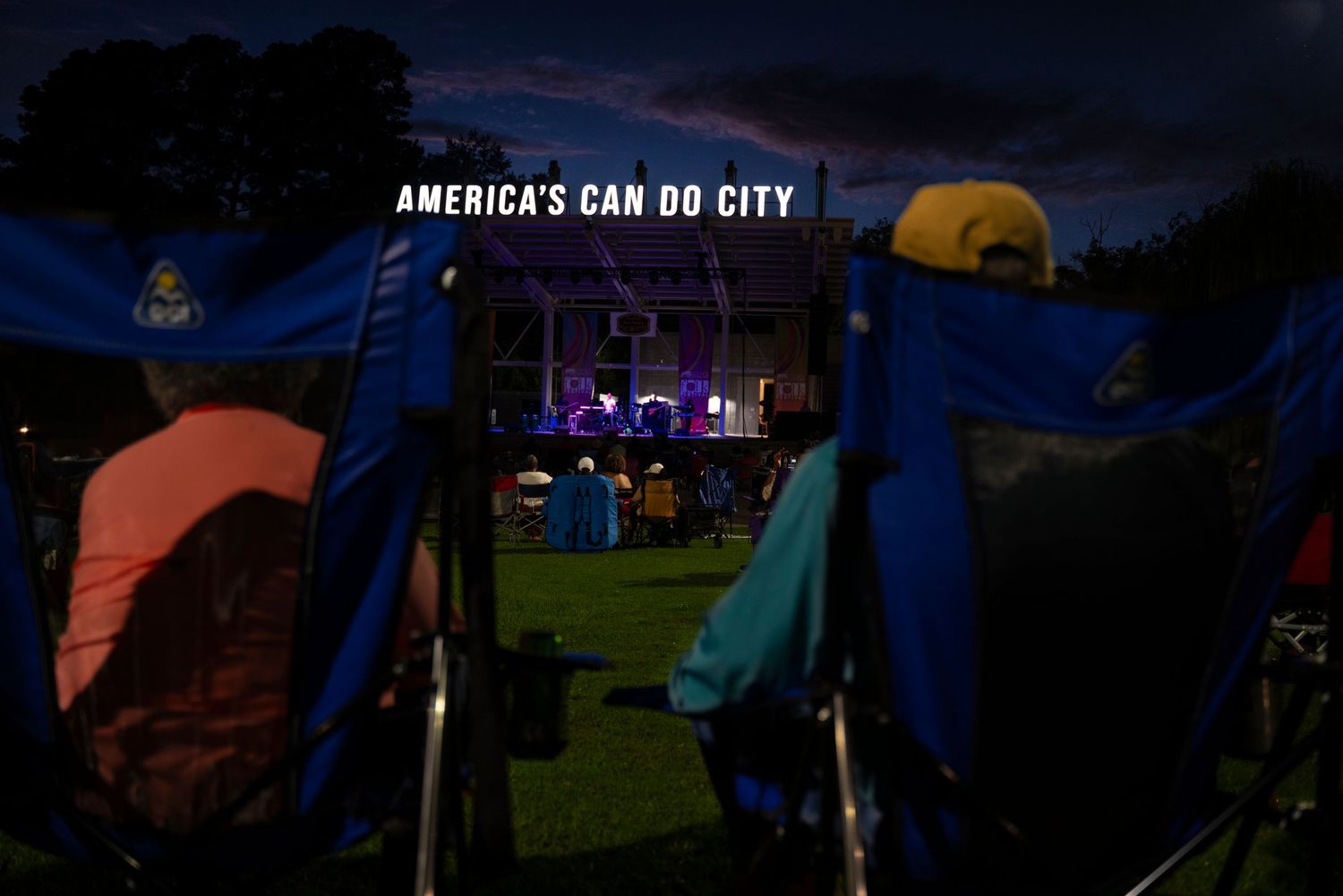 Colorful tents illuminate a dark campground at night with glowing lights creating a magical atmosphere.