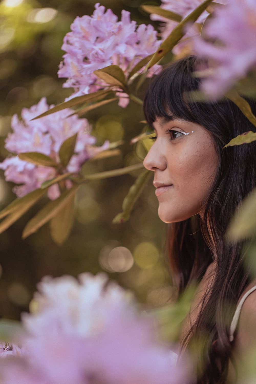 A side profile view surrounded by delicate pink cherry blossoms in soft spring lighting.