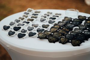 Black and white heart-shaped lapel pins or badges arranged in rows on a white display surface.