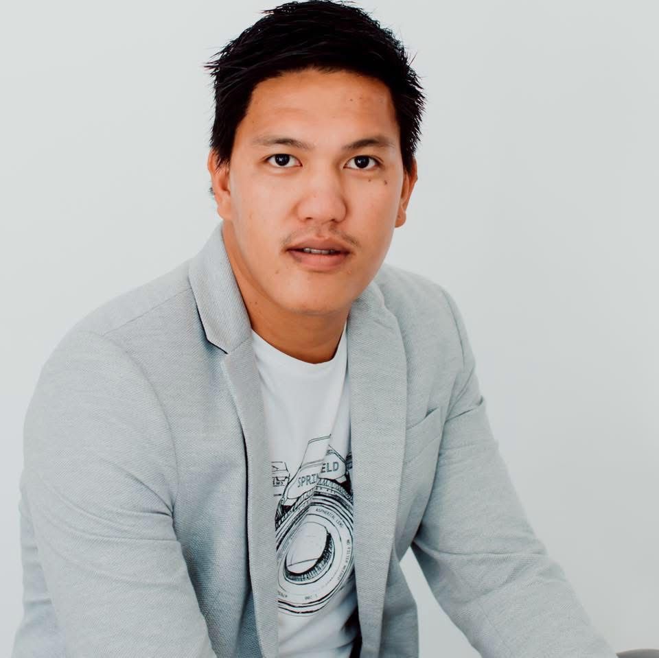 Studio portrait of person wearing casual blazer and t-shirt combination.