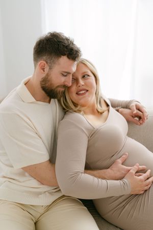 Intimate maternity session showing tender moments in bright natural window light.