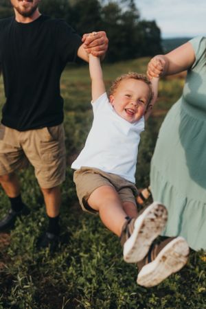 Child's feet swinging in the air during outdoor family photoshoot.