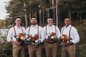 Wedding party members posing with floral bouquets against a forest backdrop.