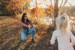 People playing and laughing together surrounded by vibrant fall colors.