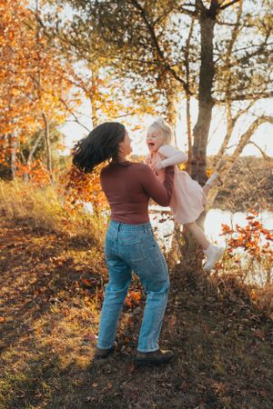 Candid moments captured on a hillside with fall colors as two people share laughter and embraces.